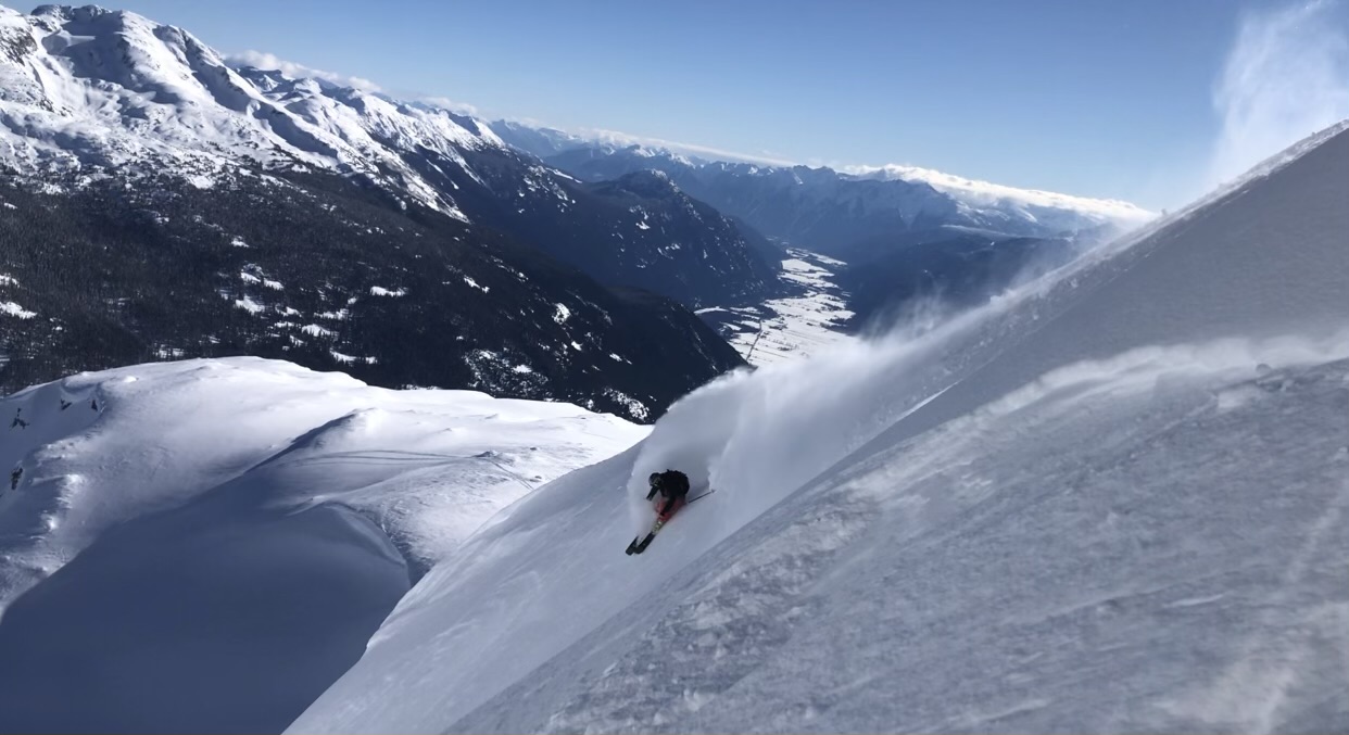 Thomas skiing through powder on a mountain slope